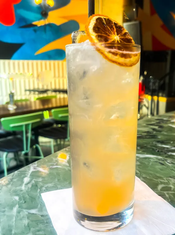 A pale citrus cocktail with a dried fruit garnish.