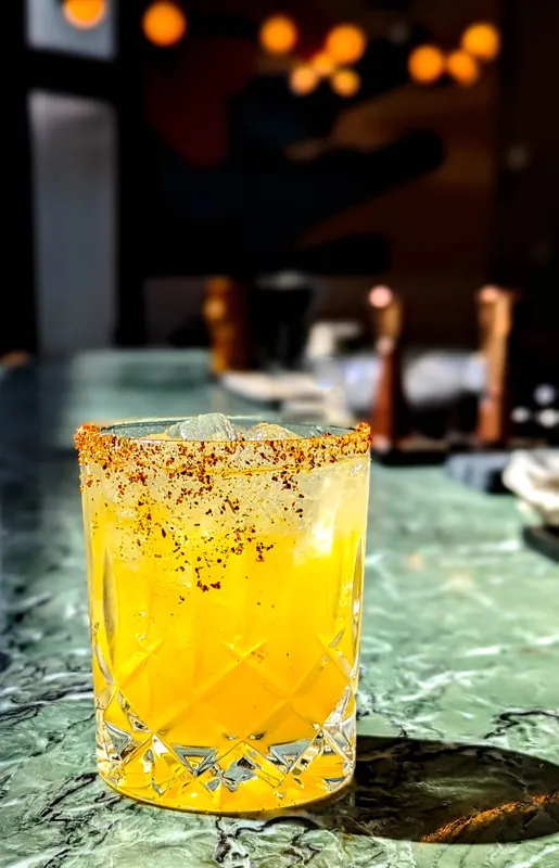 A golden cocktail with a textured rim.