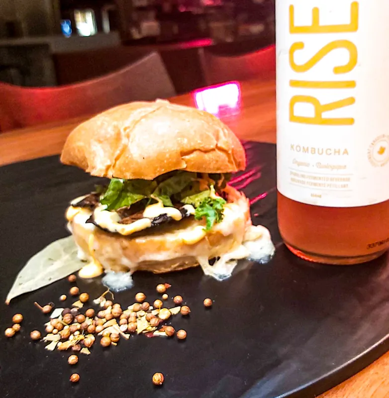 A mushroom melt sandwich served with a bottled drink.