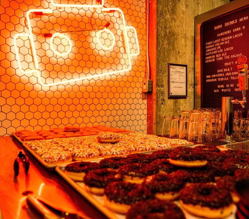 Pastries displayed beneath the glowing Bar Robo robot sign.